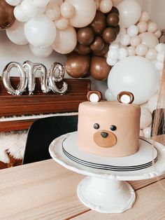 a birthday cake on a table with balloons in the background