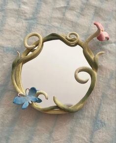 a mirror that is on top of a table with flowers in the middle and a bird flying over it