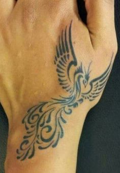 a hand with a bird tattoo on it