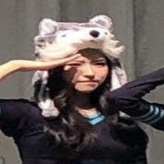 three women in matching uniforms are holding their hats up to their faces while they look at the camera