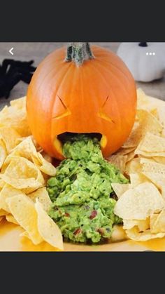 a plate with chips, guacamole and a jack - o'- lantern