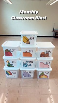 several plastic containers are stacked on top of each other in front of a sign that says month of the classroom bins