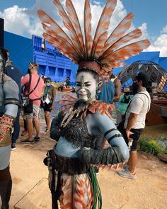 some people are dressed up in costumes and headdresses at an outdoor event