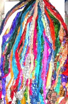 a pile of multicolored fabric sitting on top of a white table next to a wall