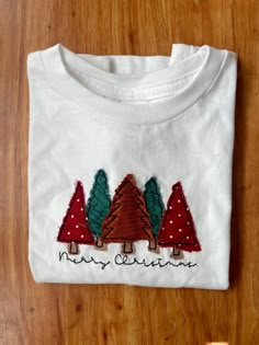 Simple, but oh so cute embroidered toddler tee! White shirt with embroidered Christmas trees and "Merry Christmas". You can choose if you want the middle tree brown or leopard print. Embroidered Christmas, Christmas Tree Shirt, Tree Shirt, Nov 1, Diy Christmas Tree, Toddler Tees, Diy Embroidery, Christmas T Shirt, Embroidery Ideas