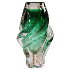 a green and white glass vase sitting on top of a table