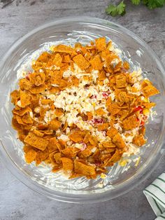 a bowl filled with chips and cheese on top of a table