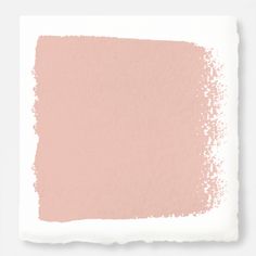 a white and pink paint swatch on top of a paper sheet that has been painted with