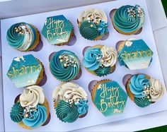 a box filled with blue and white cupcakes sitting on top of a table