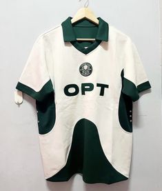 a white and green soccer jersey hanging on a wall next to a wooden hanger