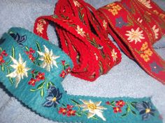 three rolls of red and blue ribbon laying next to each other on top of a towel