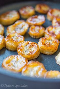 small pastries are being cooked in a skillet with powdered sugar on top