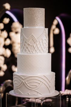 a three tiered white cake sitting on top of a table