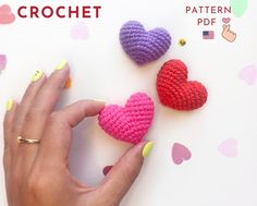 two crocheted hearts sitting on top of a table