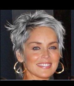 a woman with grey hair and hoop earrings