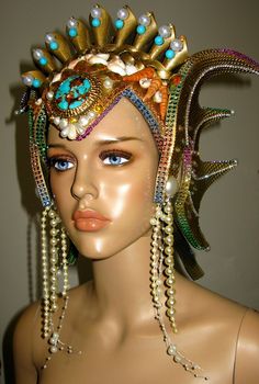 Ocean Queen Headdress, was made in strong but very light weight foam, decorate with gold paint, glitter, natural and handmade shells, rhinestones, pearls, metallic trims, natural turquoise beads and a natural turquoise and cooper front stone. The headpiece is lined with felt and have adjustable elastic on the back. Any question let me know. Thank you Carnival Costume Party Headpiece With Round Crown, Carnival Round Crown Headpieces For Costume Party, Round Crown Headpiece For Carnival Costume Party, Whimsical Tall Crown Headpiece For Carnival, Whimsical Crown Costume Hat For Carnival, Carnival Costume Headpiece With Round Crown, Tall Crown Costume Accessories For Carnival, Whimsical High Crown Hats For Costume Party, Costume Accessories With Tall Crown For Carnival