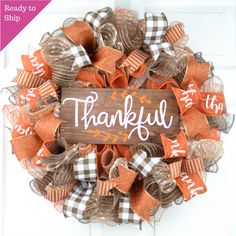 a wreath with the words, happy thanksgiving on it and some orange ribbons around it