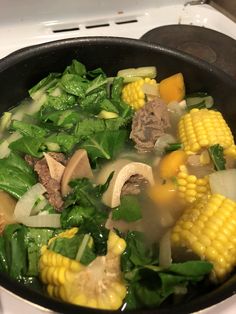 a pot filled with soup and vegetables on top of a stove