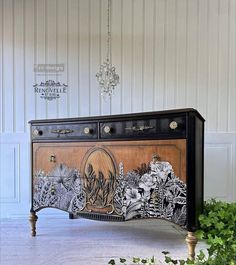 an ornate black and white cabinet with flowers on it