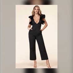 Statement Sleeve Jumpsuit Features A Daring V Neck, Structured Ruffle Sleeves, And A Fitted Waistband For A Shape Defining Silhouette That Sits Atop Straight Leg Bottoms. Elegant Stretch Jumpsuits And Rompers For Spring, Chic Fitted V-neck Jumpsuits And Rompers, Elegant Stretch Jumpsuit For Spring, Glamorous Fitted Jumpsuits And Rompers With Ruffles, Black V-neck Jumpsuit With Ruffles, Glamorous Fitted Jumpsuit With Ruffles, Elegant Party Bodysuit With Ruffles, Elegant Ruffled Party Bodysuit, Chic Fitted Jumpsuits And Rompers For Going Out