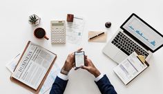 a person sitting at a desk with papers, laptop and calculator in front of them