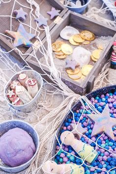 some cookies and other treats are on the ground next to two tin cans with candy in them