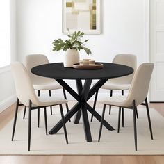 a black table with four chairs around it and a potted plant in the middle