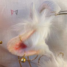 a close up of an animal's ear with red and white feathers on it