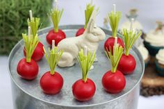 there are some red radishes on top of the cupcakes in the tin