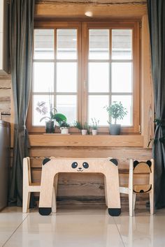 a wooden bench sitting in front of a window with potted plants on top of it