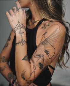 a woman with tattoos holding her hands together