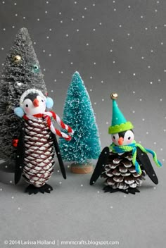 the pine cone penguins are wearing hats and scarves