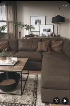 a living room with couches, tables and pictures hanging on the wall above them