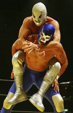 two wrestlers are wrestling in the ring with one wrestler holding the other on his back