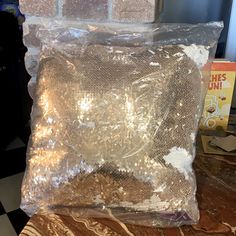 there is a plastic bag on top of a table next to a brick wall and floor