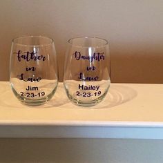 two wine glasses sitting on top of a white counter next to each other with names written on them