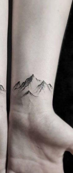 two people with matching tattoos on their feet, one is holding the other's hand