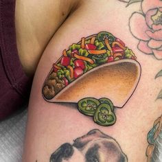 a tattoo with a taco and a dog on it's thigh is shown