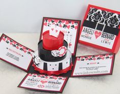 a red and black wedding cake on top of a table with matching place cards in front of it