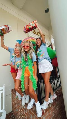 some girls are posing for the camera with their hats on and one girl is holding a cake