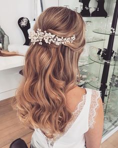 a woman sitting in front of a mirror wearing a hair comb with flowers on it