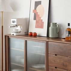 a wooden cabinet sitting next to a lamp on top of a hard wood floor