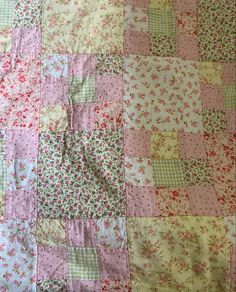 a pink and green patchwork quilt with flowers on it