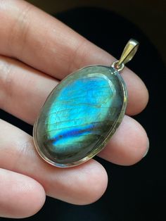 This oval Labradorite pendant is handmade and set in solid Sterling Silver. Each unique Labradorite stone has opalescent colors and shimmering patterns that are pure magic! Labradorite is in the Moonstone and Spectrolite mineral family and gets its name from the place it was originally discovered: Labrador, Canada. It is often referred to as a "Dream Stone" as it enhances the power of dreams and manifestation. Labradorite has the power to help you make your dreams come true! Shoot for the stars! Oval Labradorite Necklace With Large Stone, Oval Moonstone Natural Stones, Oval Natural Moonstone Gemstones, Oval Labradorite Cabochon Jewelry, Oval Cabochon Labradorite Jewelry, Spiritual Labradorite Jewelry With Natural Inclusions, Artisan Oval Labradorite Necklace, Unique Iridescent Oval Jewelry, Unique Oval Iridescent Jewelry