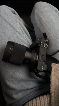 a camera sitting on the lap of someone's legs