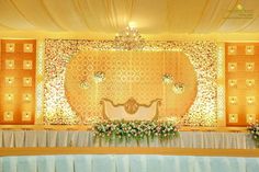 an elaborately decorated stage set up with flowers and candles in front of the backdrop