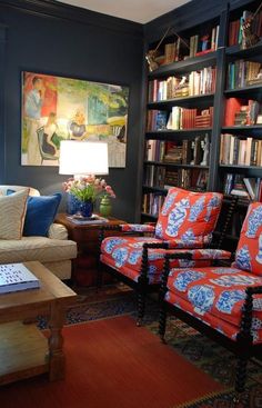 a living room filled with lots of furniture and bookshelves covered in colorful pillows