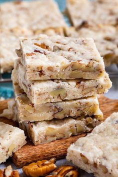 several pieces of pecan bar stacked on top of each other with nuts around them