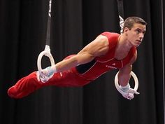 a man is doing aerial tricks on rings