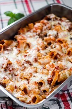 a casserole dish with meat and cheese in it on a checkered table cloth